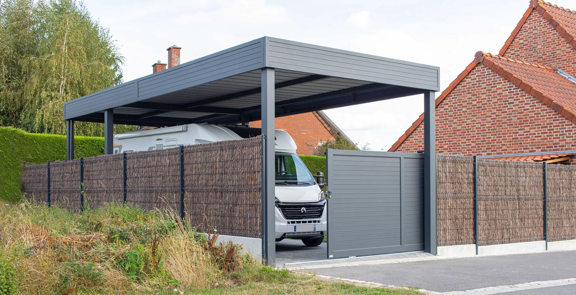 Portail Auteuil coulissant manuel assorti à un carport grande hauteur, conçu pour un camping-car, installation Newtech Fermetures à Bourghelles