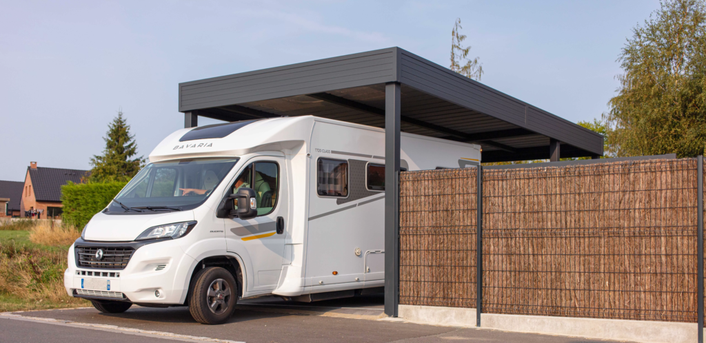 Camping-car stationné sous un carport aluminium ORION grande hauteur avec portail assorti, installé par Newtech Fermetures