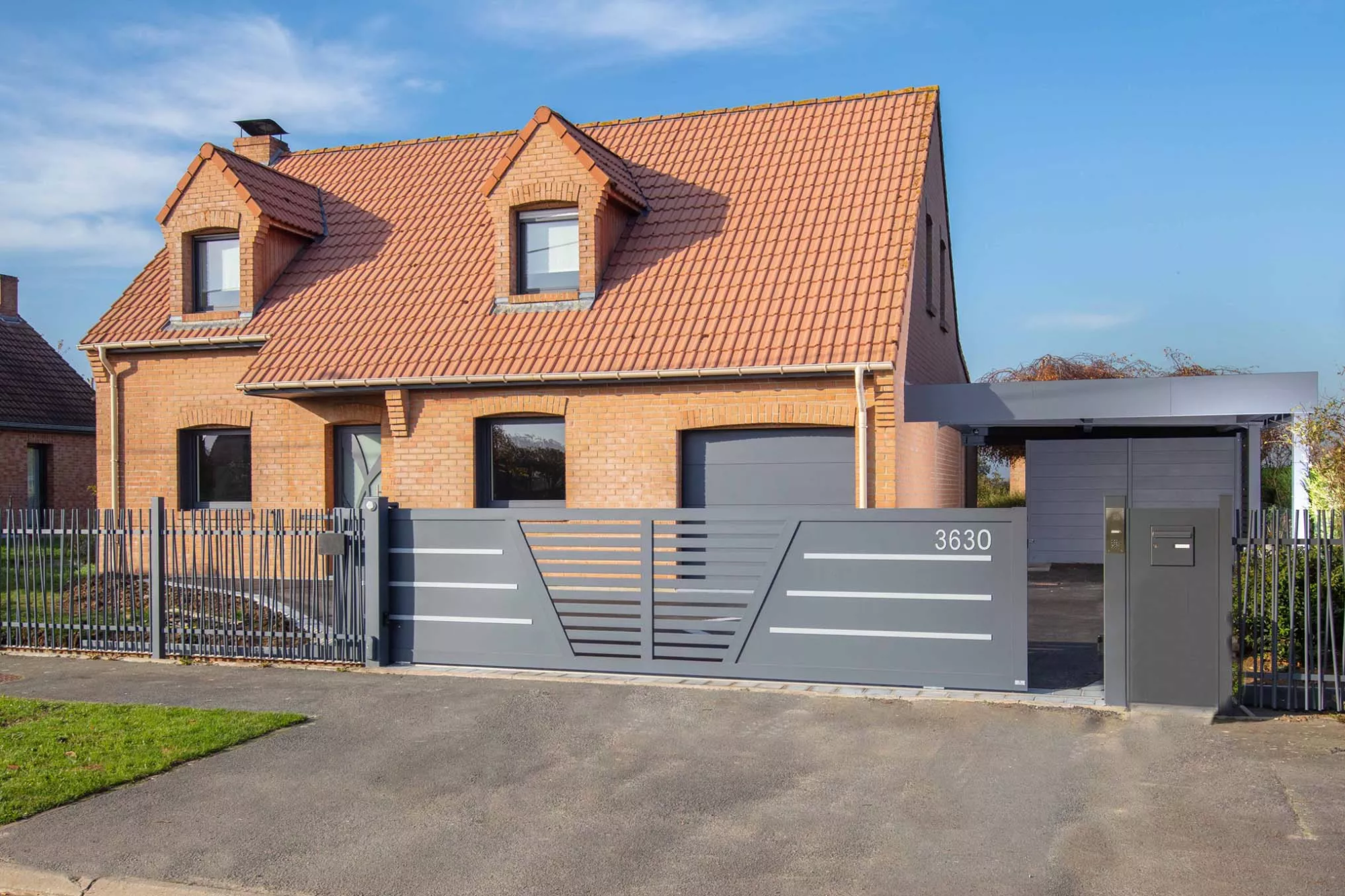 Ensemble aluminium installé à Bailleul par Newtech Fermetures : portail coulissant, clôture effet bambou et carport ORION avec abri