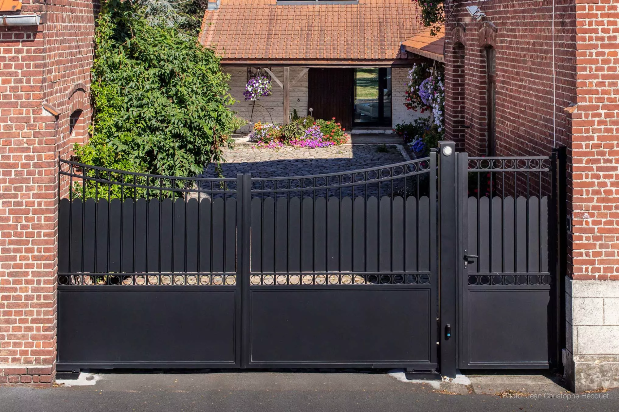 Vue d’ensemble d’un portail battant traditionnel en aluminium noir avec portillon et décors ronds – Douai, installation Newtech