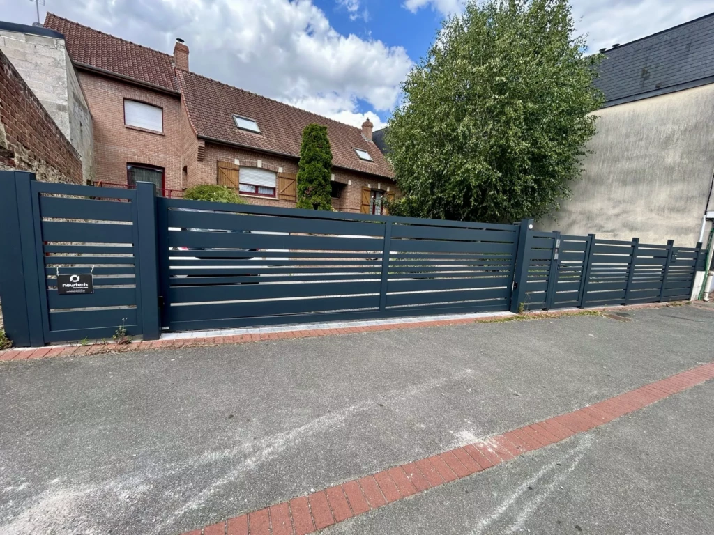 Installation d’un portail coulissant aluminium SAUMUR en pente, portillon et clôture ajourée avec boîte aux lettres intégrée à Saint-Nicolas Arras