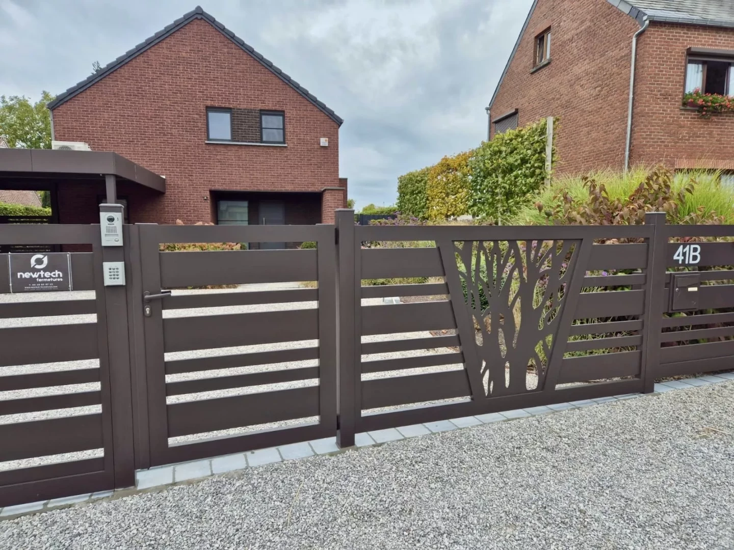 Portail aluminium coulissant sur pente modèle Saumur avec décor laser, brun gris RAL 8019, réalisation Newtech Autreppe Belgique