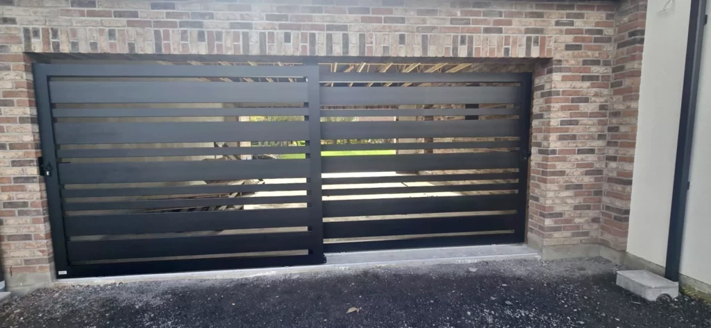 Installation à Herrin d’un double portail coulissant aluminium noir 9005 modèle Saumur, réalisé sur mesure par Newtech Fermetures.