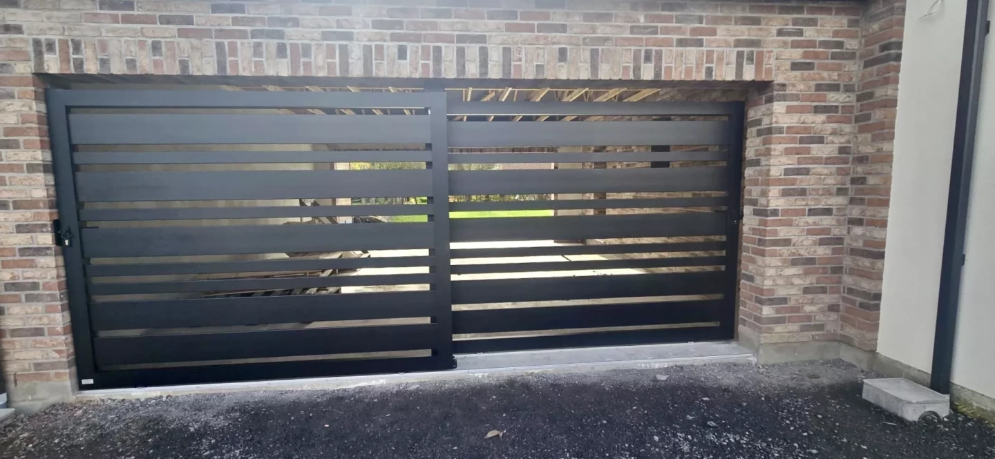 Installation à Herrin d’un double portail coulissant aluminium noir 9005 modèle Saumur, réalisé sur mesure par Newtech Fermetures.