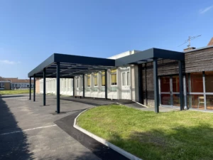 Préau aluminium MODULEO autoporté avec toiture polycarbonate et bandeau Horizon – installation Newtech Fermetures à Attiches