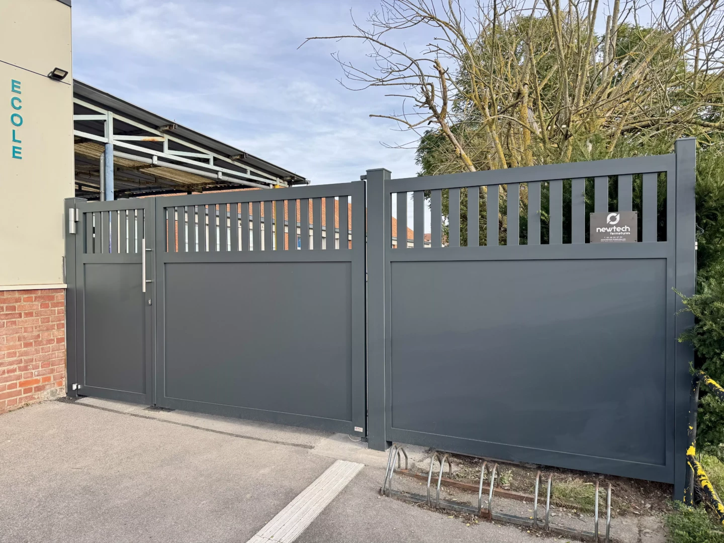 Vue d’ensemble du portail aluminium sur mesure installé à Baisieux, avec vantaux inégaux, gâche électrique et ferme-porte hydraulique.