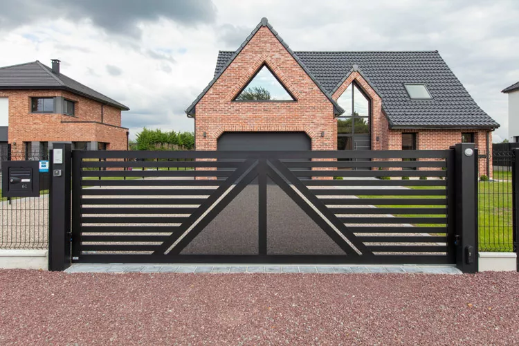 Portail coulissant création en aluminium, couleur noir 9005, installé par Newtech Fermetures devant une maison en brique à Flines-lez-Râches.