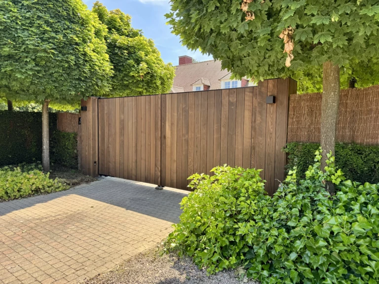 Vue d'angle d'un portail battant aluminium avec remplissage en frêne thermotraité