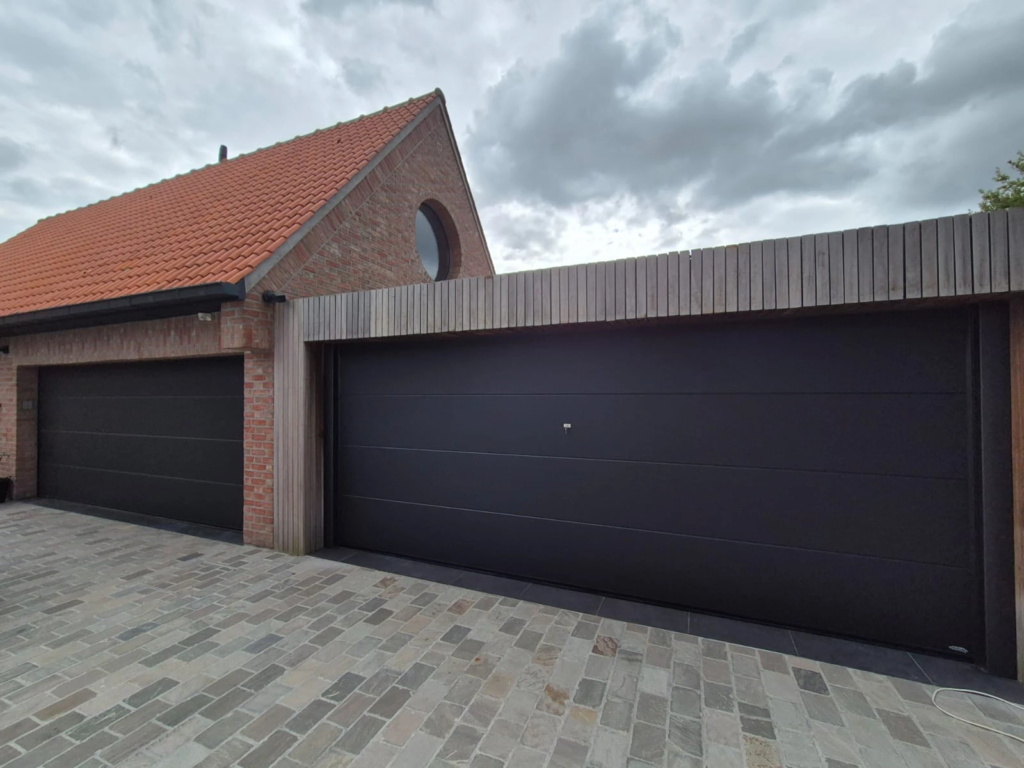Porte de garage sectionnelle moderne noire intégrée dans un habillage bois à Gruson