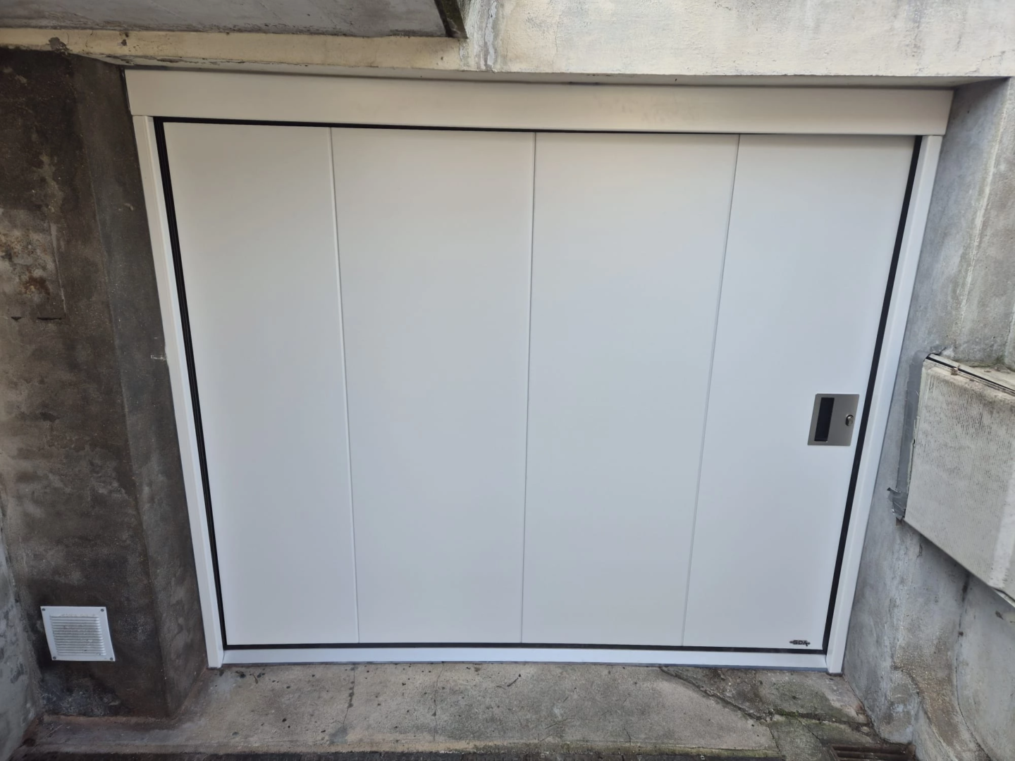 Porte de garage sectionnelle à ouverture latérale blanche installée à Mouvaux